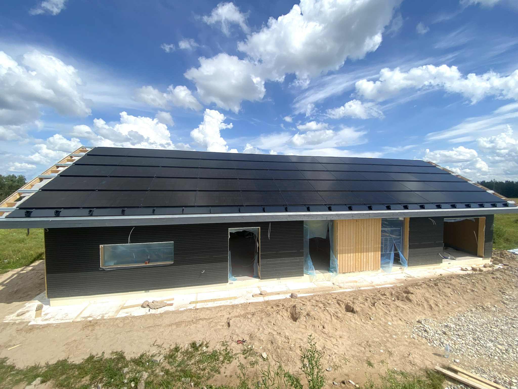 Wide view of modern dark house with complete HolaRoof solar coverage